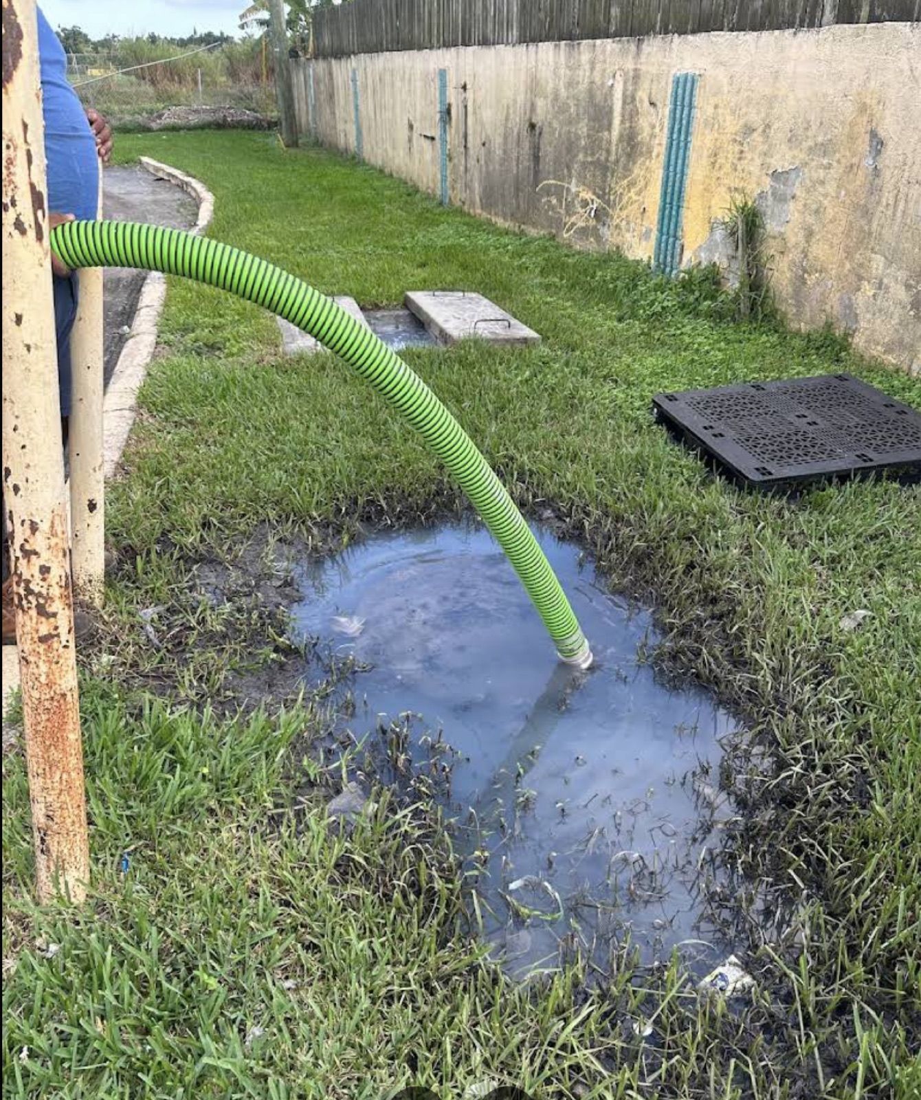 The suction hose running across a yard into a septic access point.