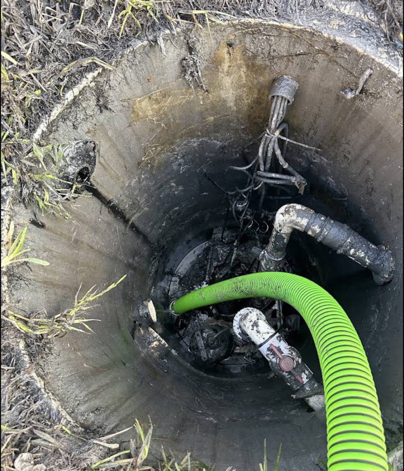Looking down into an open pump chamber with the suction hose reaching the bottom.